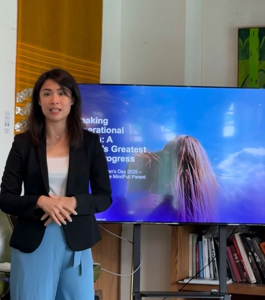 Michelle Lim speaking to a group, standing beside a presentation screen