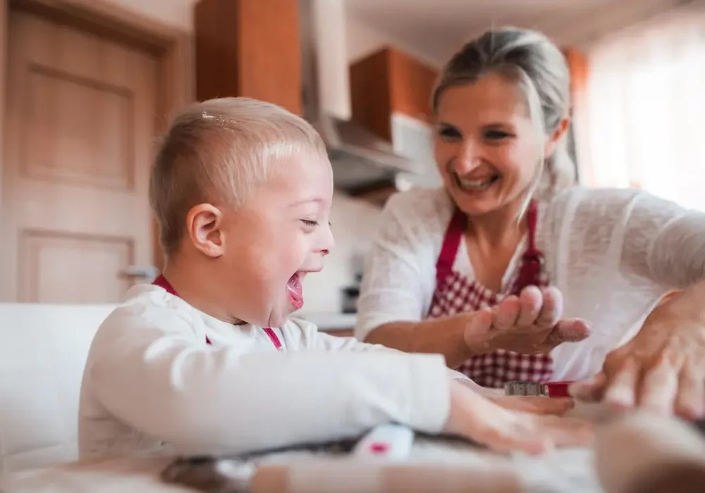 A mother and her young son laughing together while baking
